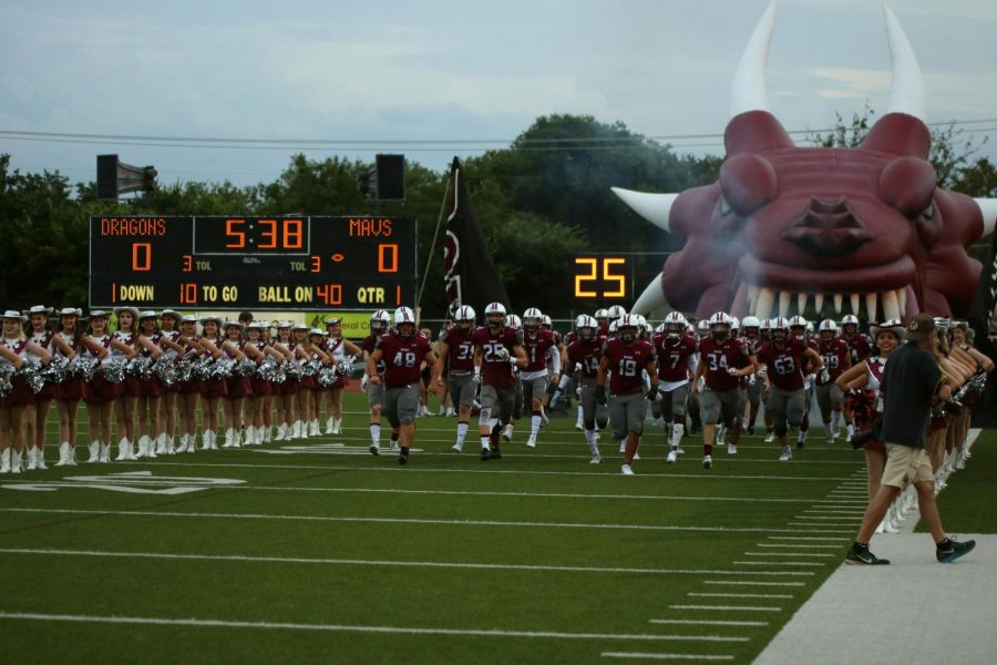 The Dragons run onto the field prior to their home and district opener.